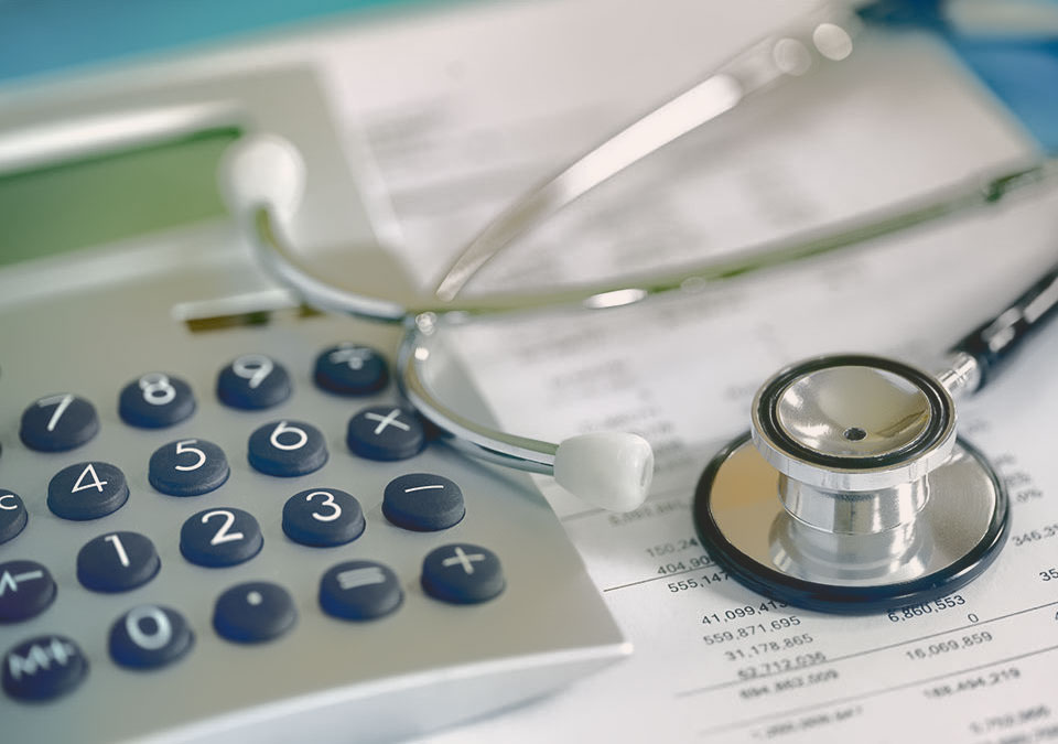 General Surgery Billing - A stethoscope laying near a calculator