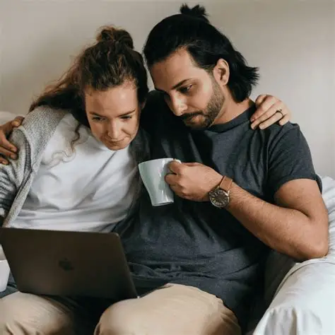 two humans grasping each other and looking at a screen